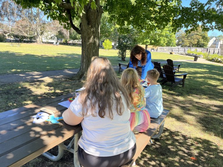 Family at craft table with SCA intern Cecelia Halle